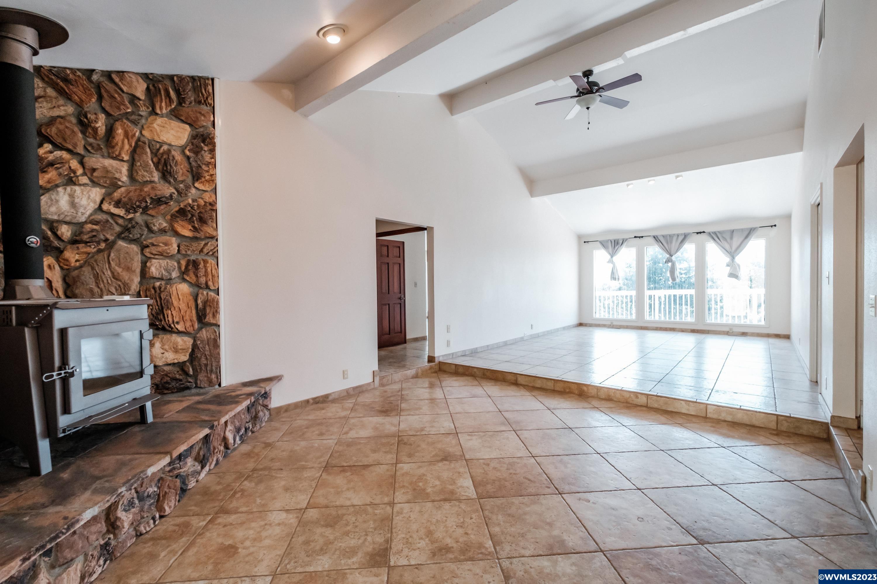 8588 Skyline Road South Salem, OR 97306 - Photo 21 of 42 a view of an empty room with a fireplace and a window
