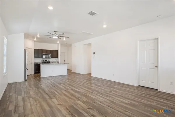 a view of kitchen with cabinets appliances and wooden floor