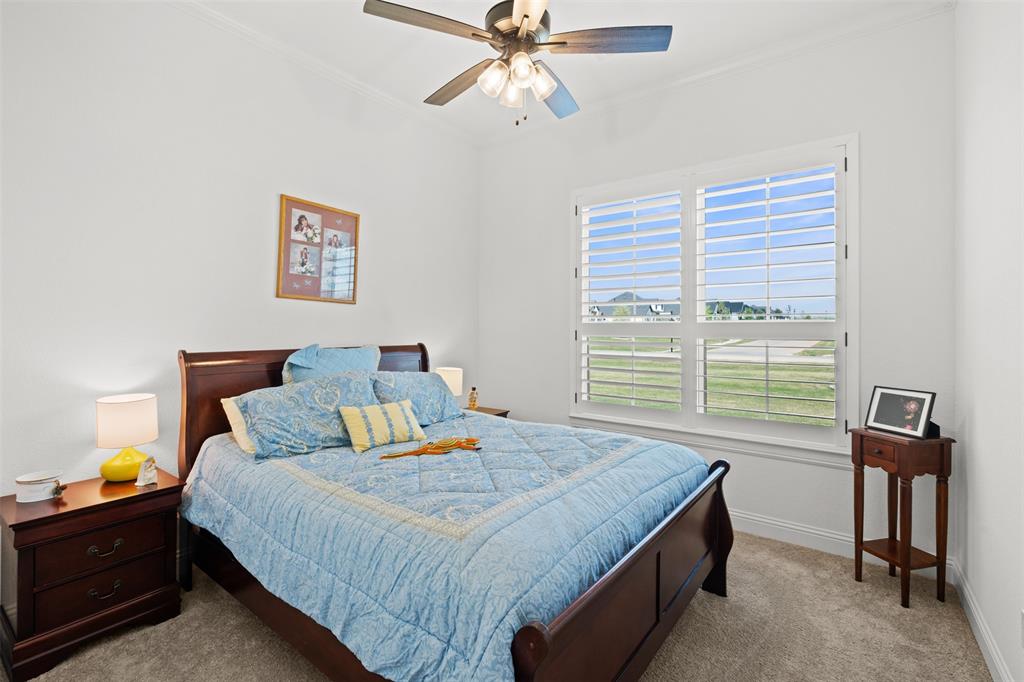 2012 Southern Rise Court Granbury, TX 76049 - Photo 19 of 40 a bedroom with a bed and a chandelier