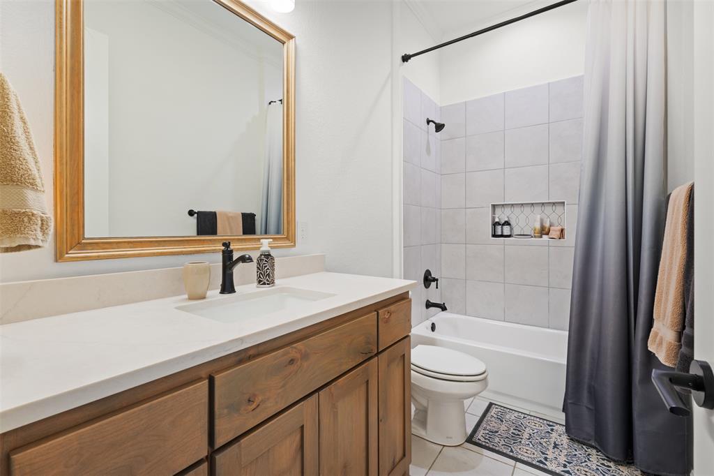 2012 Southern Rise Court Granbury, TX 76049 - Photo 21 of 40 a bathroom with a granite countertop sink toilet a mirror and shower