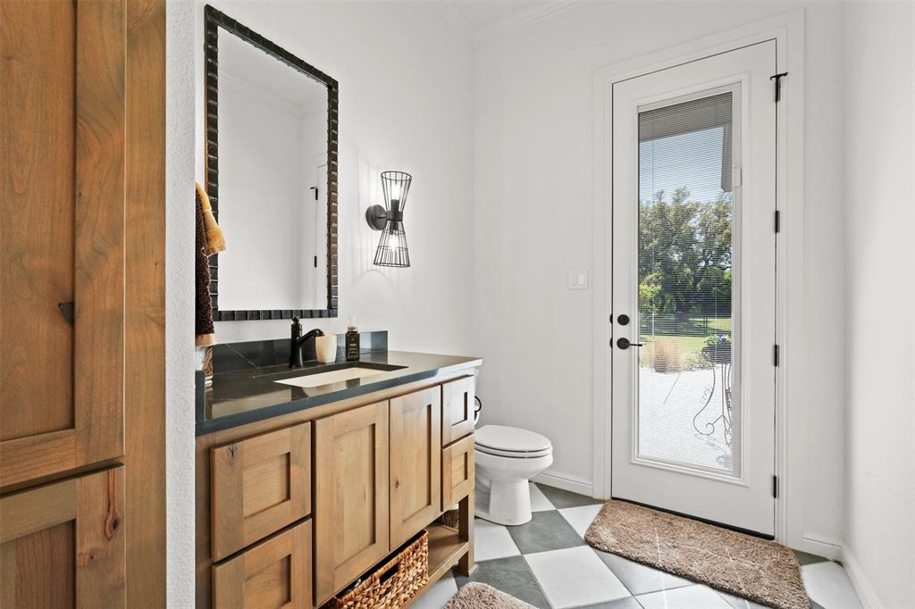 2012 Southern Rise Court Granbury, TX 76049 - Photo 24 of 40 a bathroom with a granite countertop sink a toilet and mirror