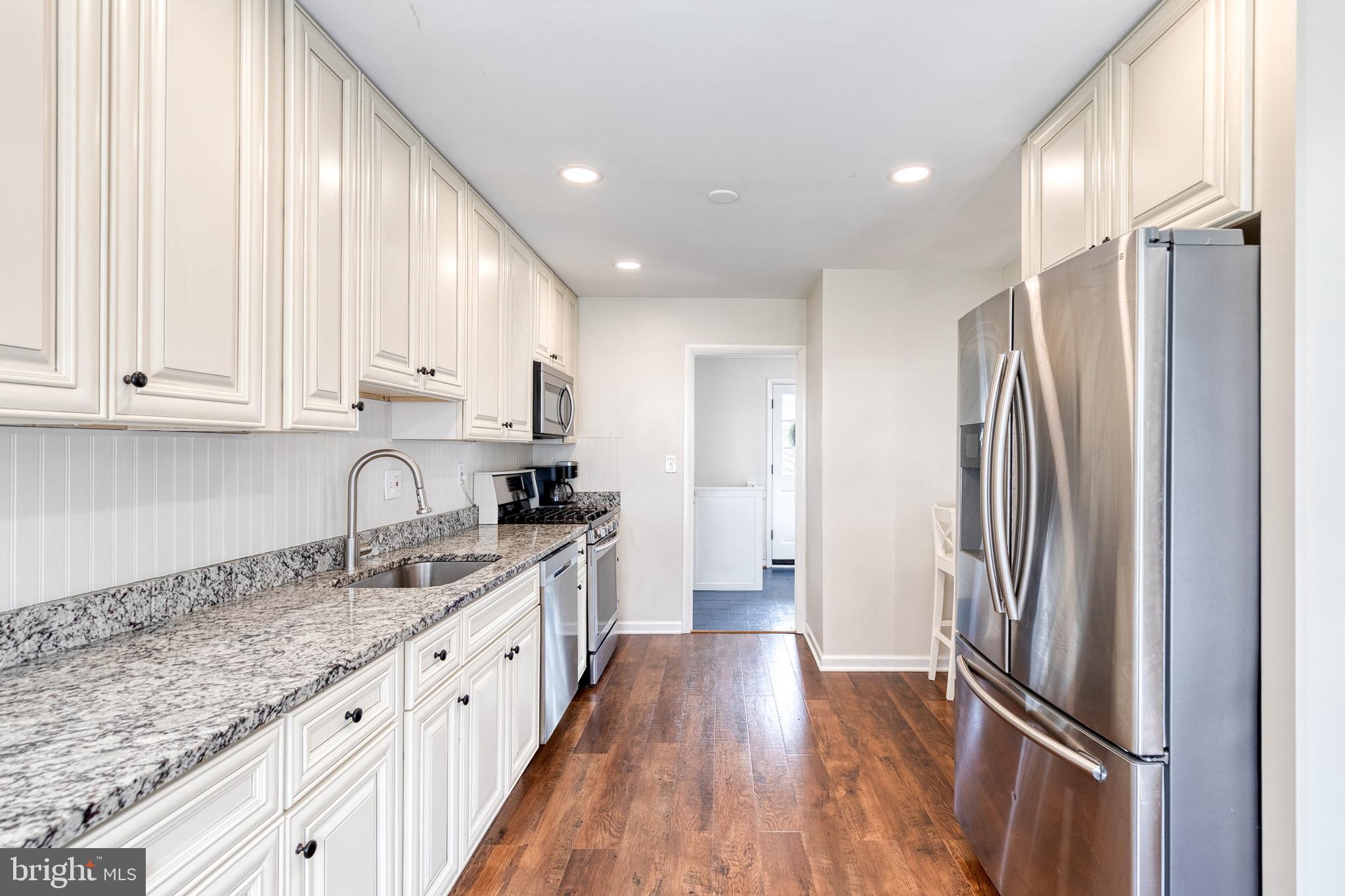 8206 Burnley Road Towson, MD 21204 - Photo 12 of 37 a kitchen with stainless steel appliances granite countertop a refrigerator a sink and white cabinets