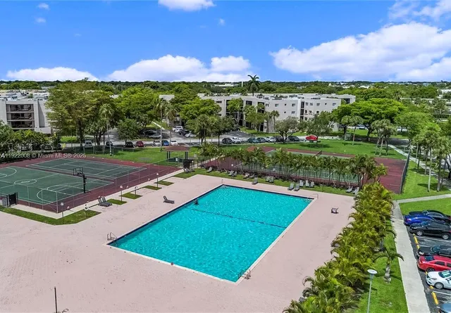 an aerial view of residential houses with outdoor space and parking
