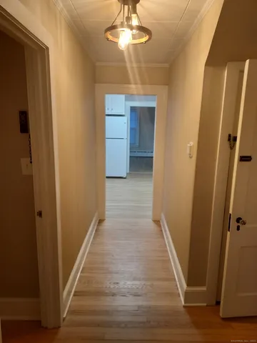 an empty room with wooden floor and fan