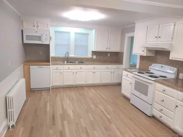 a kitchen with white cabinets and white appliances