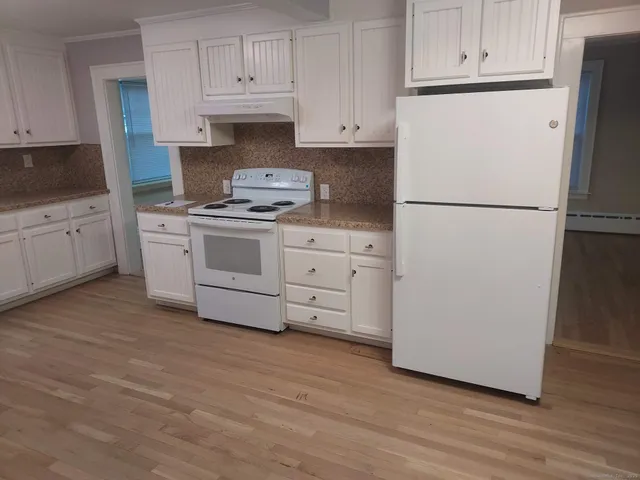 a view of a room with wooden floor