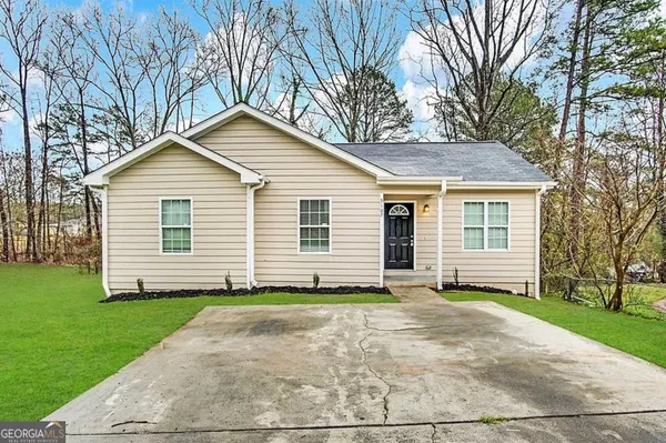 a front view of a house with a garden and yard