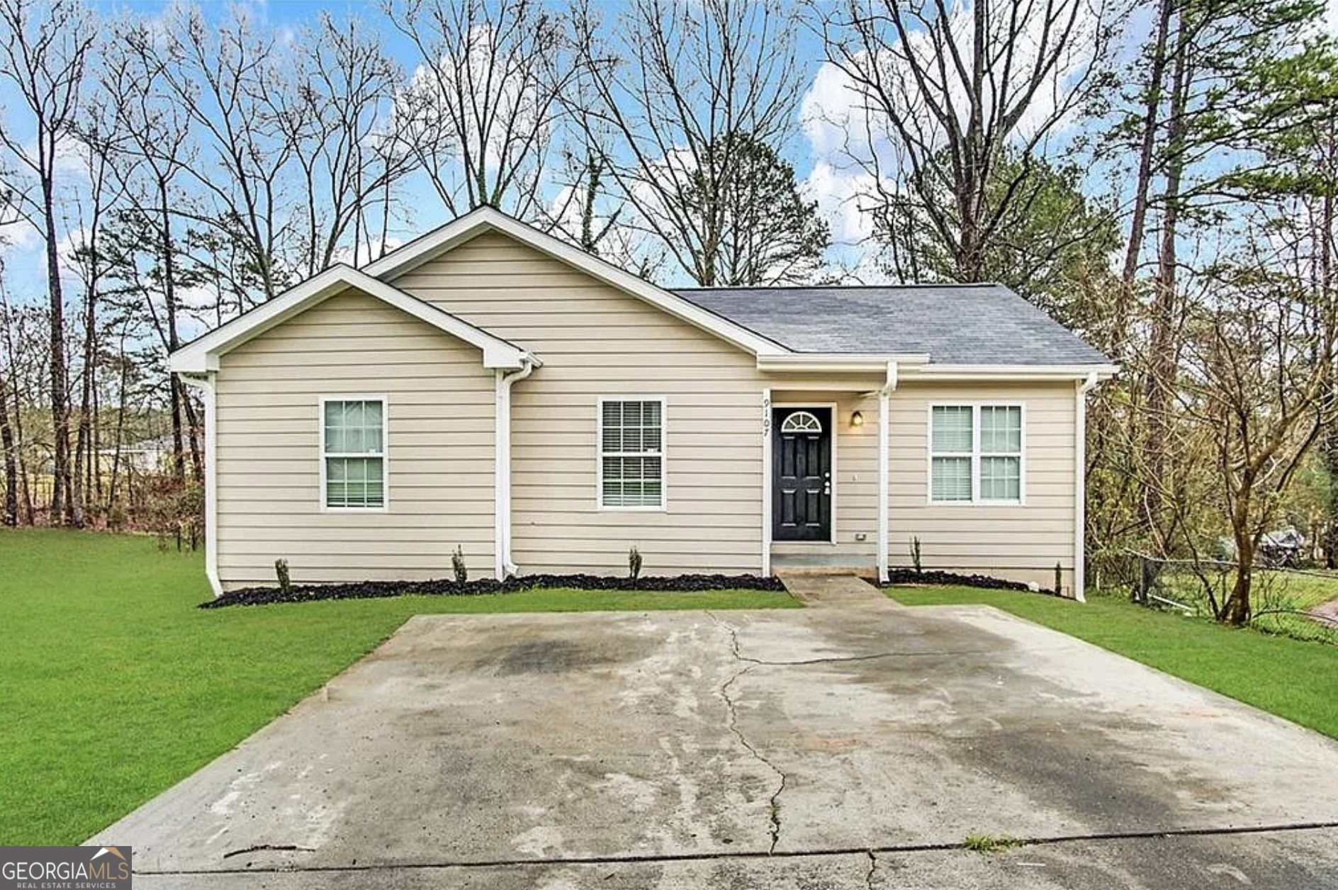 a front view of a house with a garden and yard