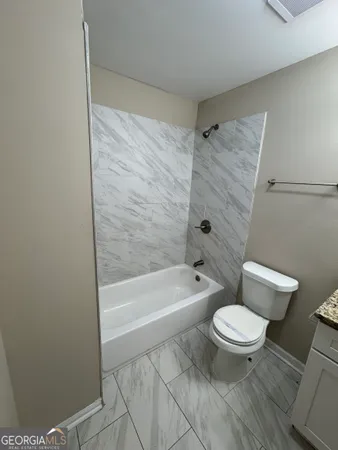 a bathroom with a toilet and a bath tub