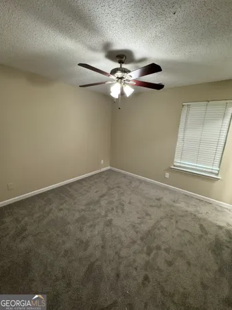 en empty room with windows and fan