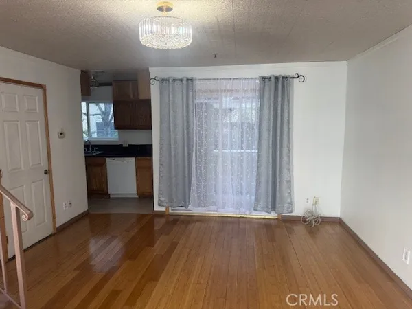 a view of a room with wooden floor and a window