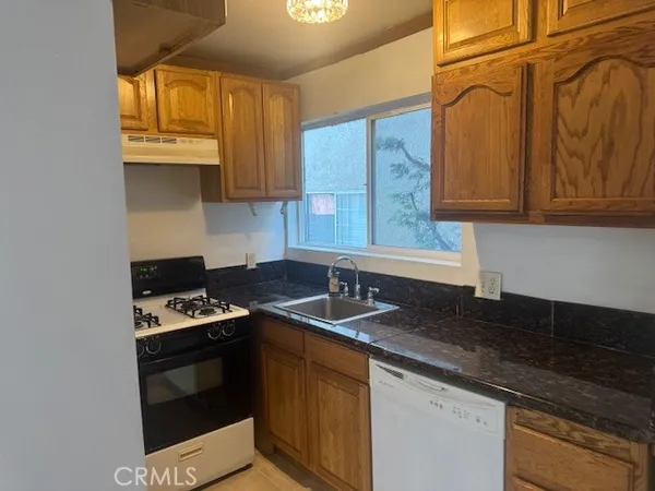 a kitchen with stainless steel appliances granite countertop a sink stove and cabinets
