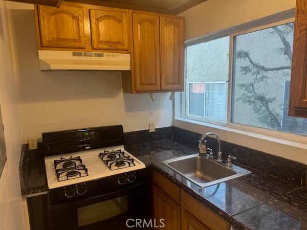 a kitchen with stainless steel appliances granite countertop a sink stove and cabinets