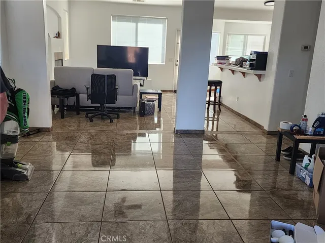 a living room with furniture a flat screen tv and a table