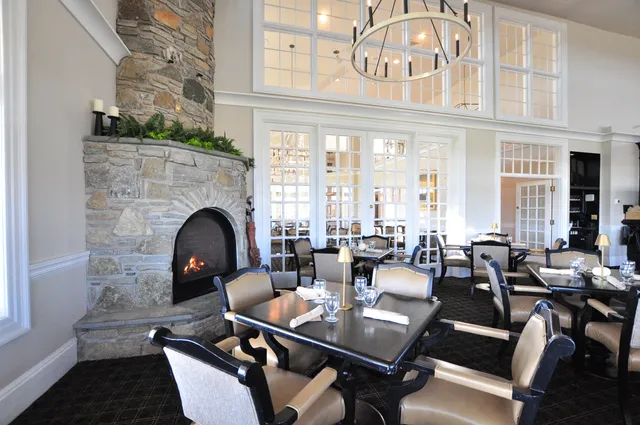 a living room with furniture a fireplace and large windows