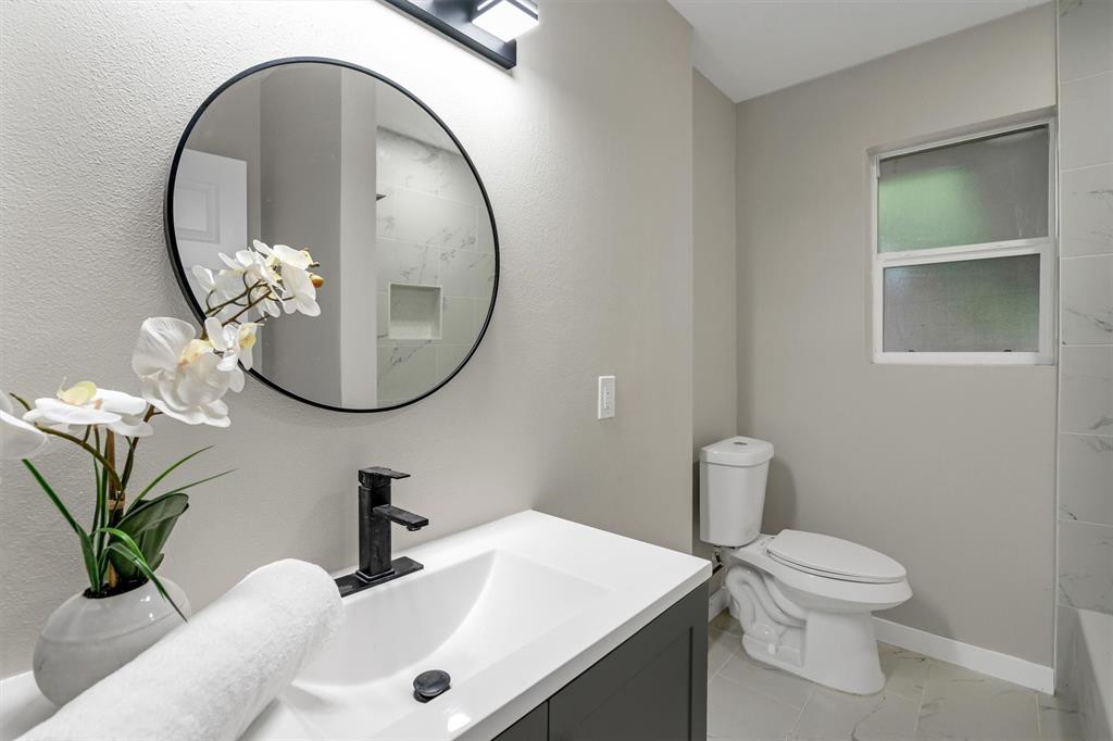 4815 Kelman Street Dallas, TX 75214 - Photo 29 of 37 Bathroom featuring a modern vanity with a white countertop, vessel sink, and matte black faucet