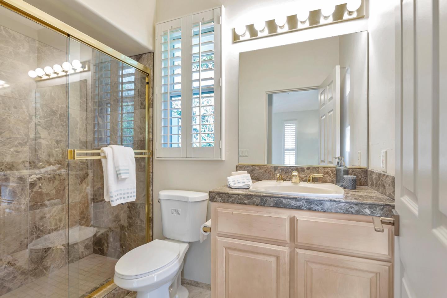 3120 Middle Ranch Road Pebble Beach, CA 93953 - Photo 17 of 39 a bathroom with a granite countertop sink toilet a mirror and shower