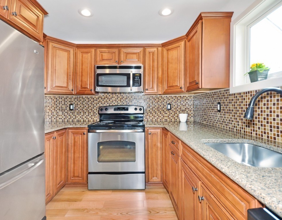 36 Todd Pond Road, Unit 36 Lincoln, MA 01773 - Photo 8 of 26 a kitchen with stainless steel appliances granite countertop a sink stove and microwave