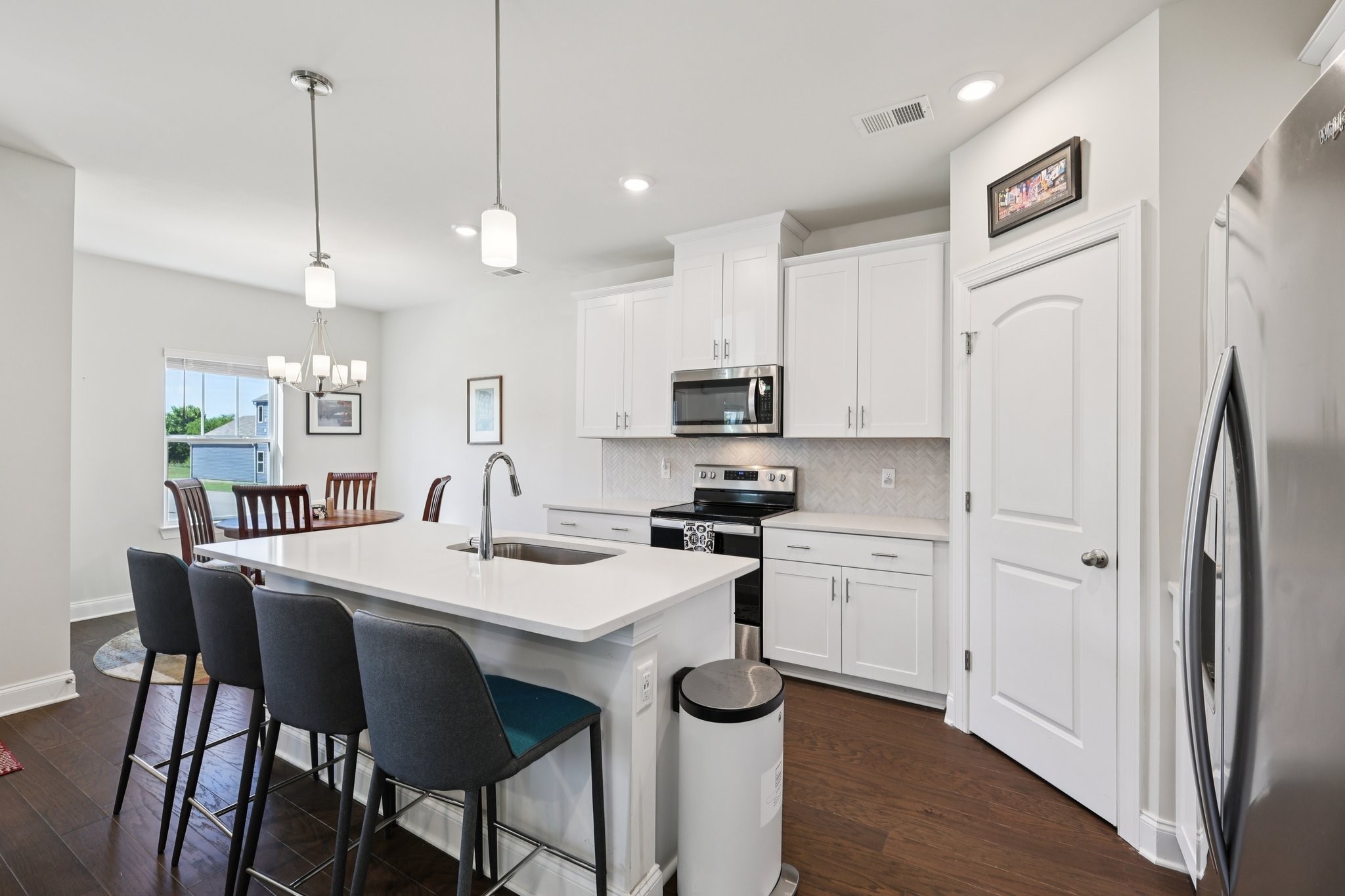 668 Taylor Bend Columbia, TN 38401 - Photo 7 of 35 a kitchen with stainless steel appliances granite countertop a refrigerator a sink dishwasher a stove a dining table and chairs with wooden floor
