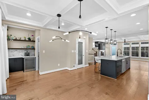 a kitchen with kitchen island a sink a counter top space and living room view