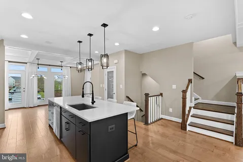 a kitchen with stainless steel appliances granite countertop a table chairs and a refrigerator