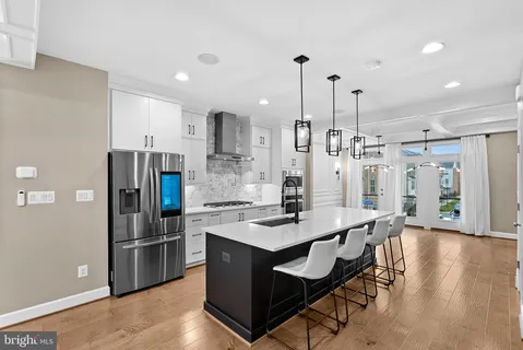 a open kitchen with stainless steel appliances granite countertop a stove and a wooden floors