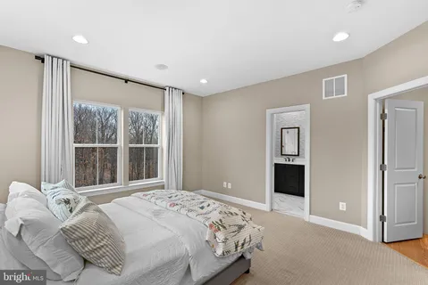 a bathroom with a double vanity sink and mirror with toilet