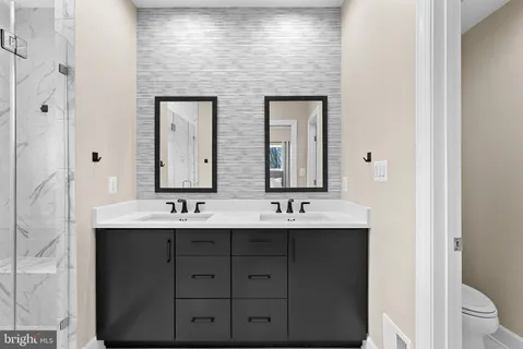 a bathroom with a granite countertop sink a shower and a mirror