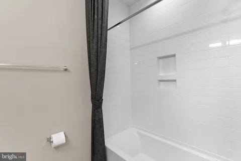 a view of an empty room with a cabinet and flat screen tv