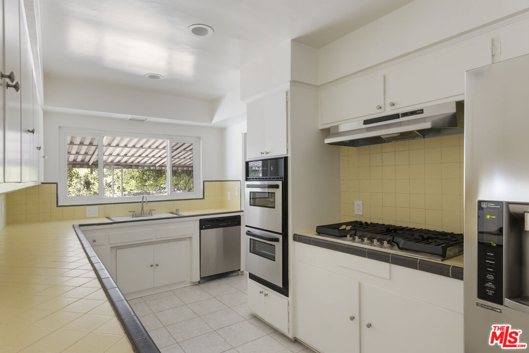15508 Royal Ridge Road Sherman Oaks, CA 91403 - Photo 11 of 39 a kitchen with a stove and a refrigerator