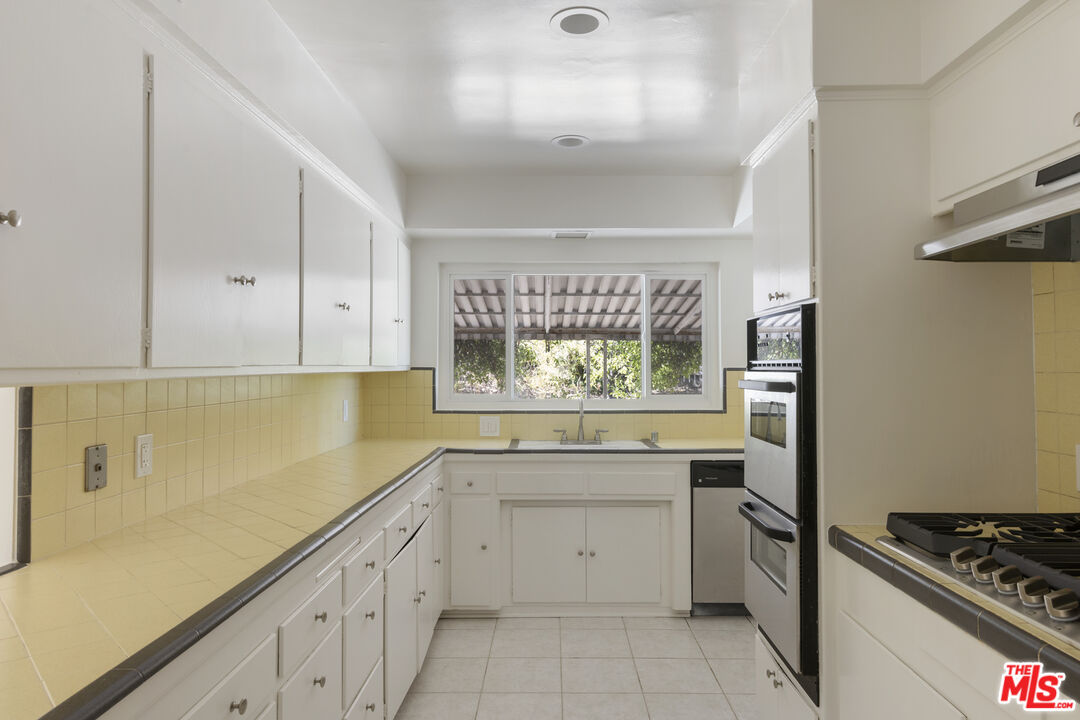 15508 Royal Ridge Road Sherman Oaks, CA 91403 - Photo 12 of 39 a kitchen with white cabinets and appliances