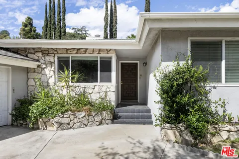 a view of a house with potted plants