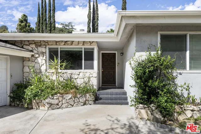 a view of a house with potted plants
