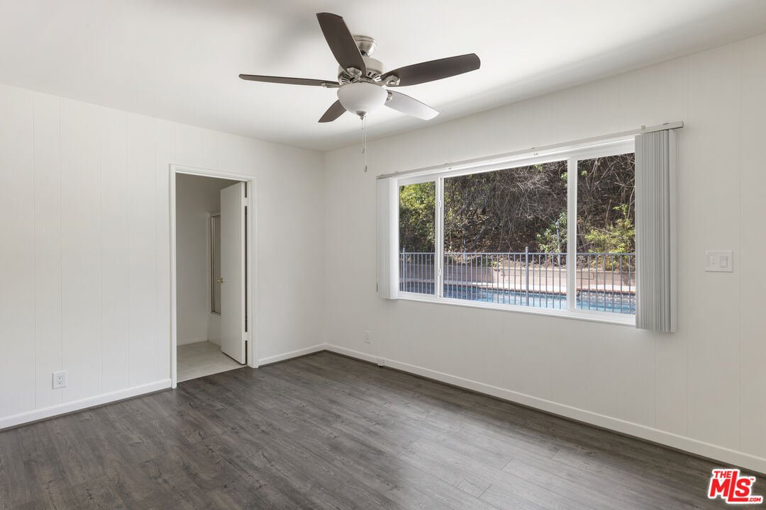15508 Royal Ridge Road Sherman Oaks, CA 91403 - Photo 22 of 39 an empty room with wooden floor and windows