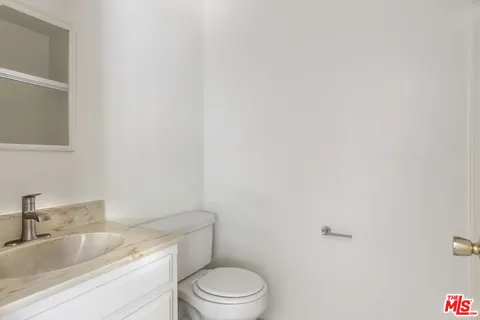 a bathroom with a granite countertop toilet and sink