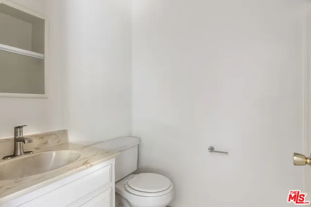 a bathroom with a granite countertop toilet and sink