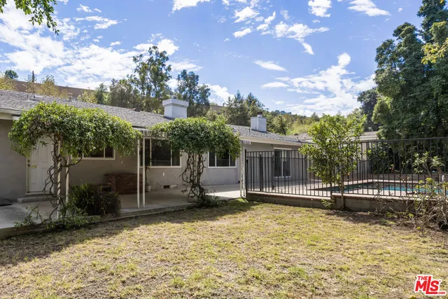 a view of a house with backyard and a tree