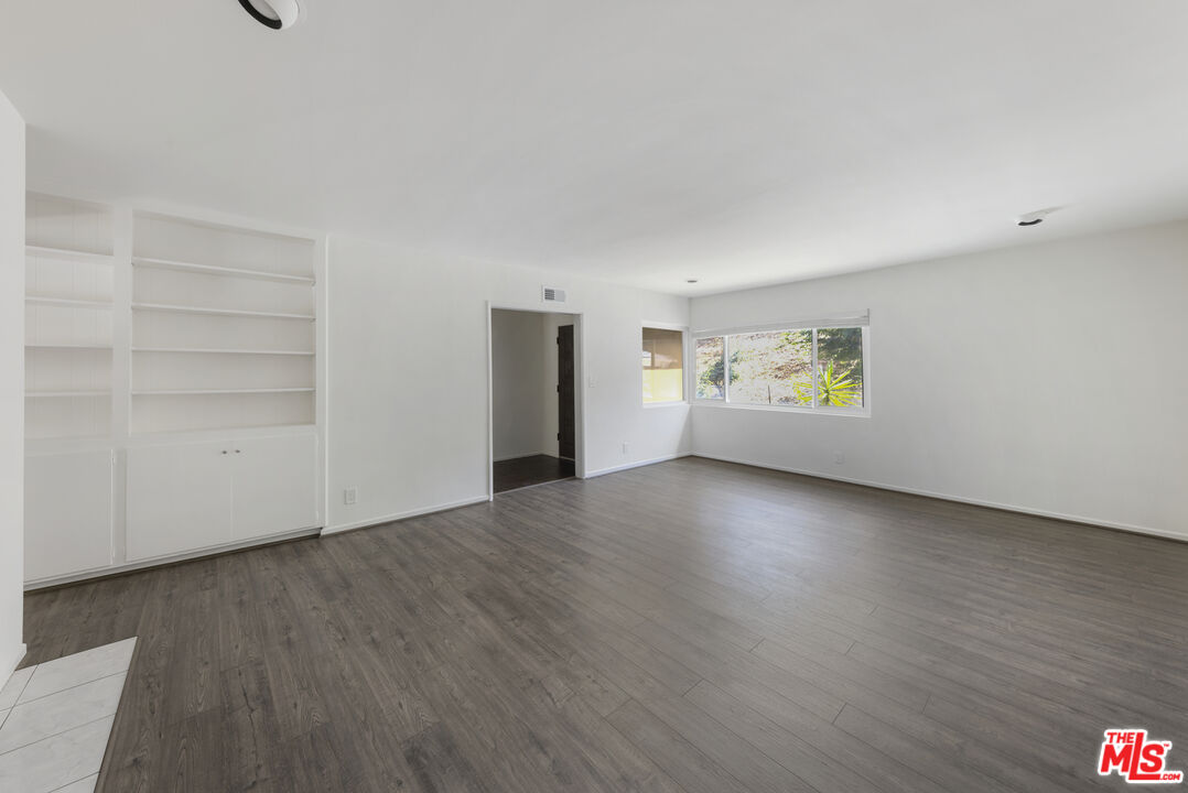 15508 Royal Ridge Road Sherman Oaks, CA 91403 - Photo 6 of 39 a view of an empty room with a window and wooden floor