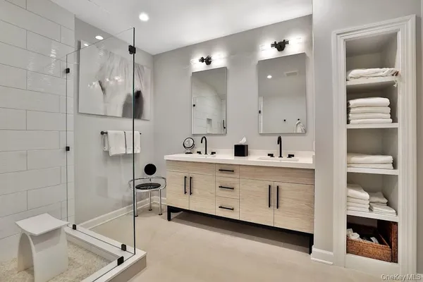 a en suite bathroom with a double vanity sink and a mirror