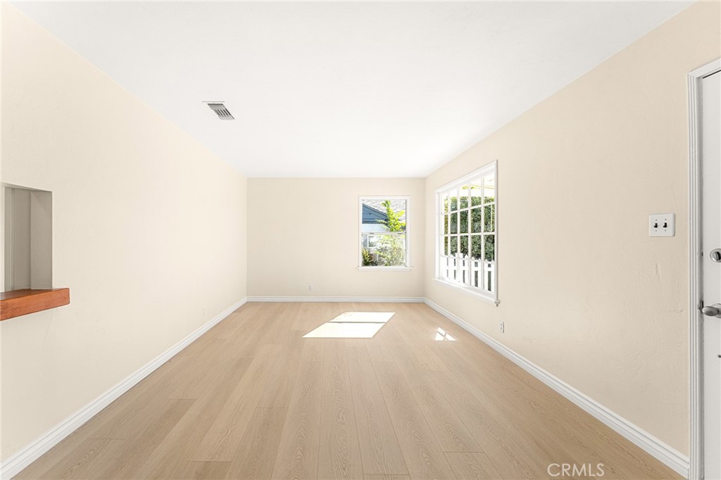 1253 Cottonwood Road Banning, CA 92220 - Photo 14 of 22 a view of an empty room with wooden floor and a window