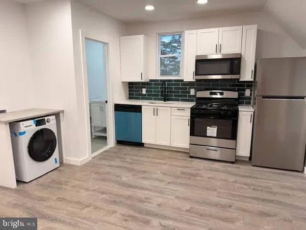 a kitchen with a refrigerator and a stove top oven