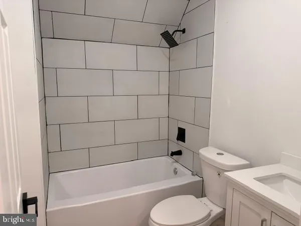 a white bath tub sitting next to a white toilet and sink