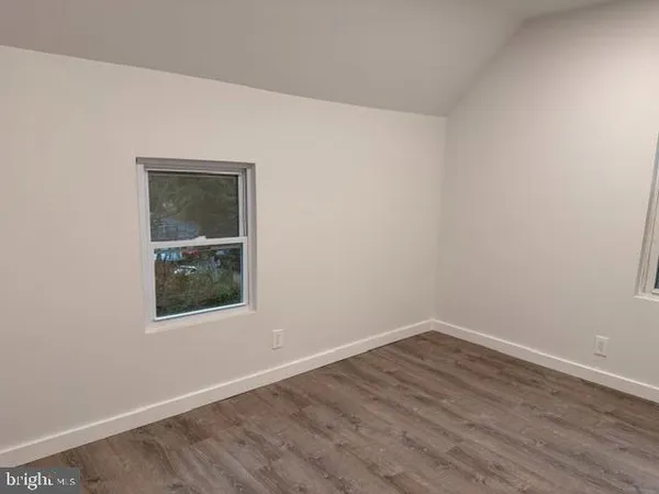 an empty room with wooden floor and a window