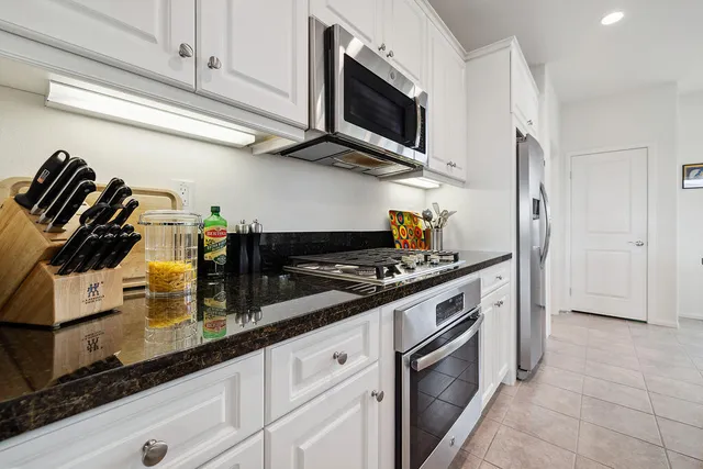 a kitchen with stainless steel appliances granite countertop a sink and a stove