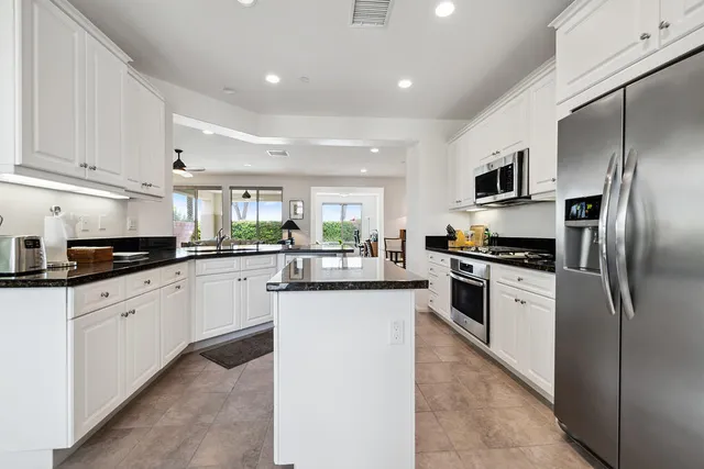 a kitchen with stainless steel appliances granite countertop a refrigerator sink and cabinets