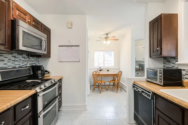 a kitchen with stainless steel appliances granite countertop a stove a sink and a microwave
