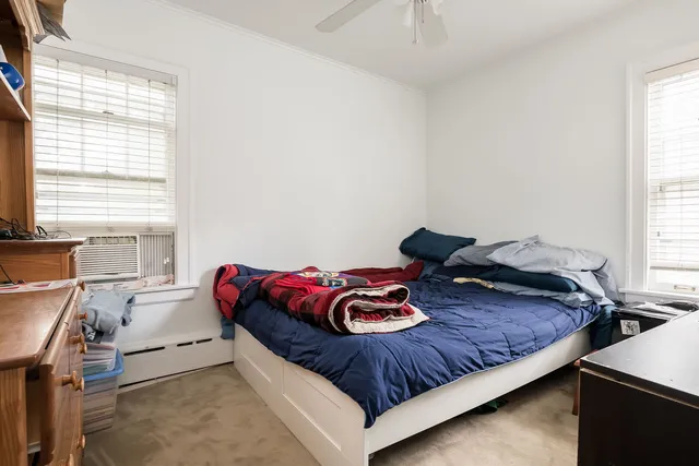a bed sitting in a bedroom next to a window