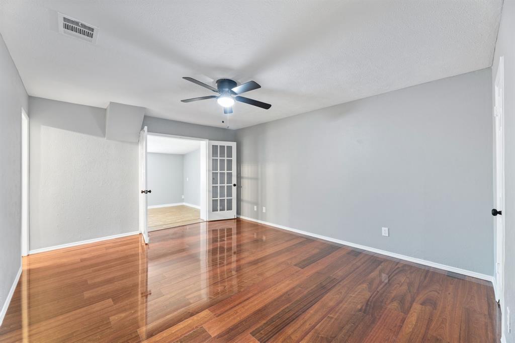 100 West Way Drive Allen, TX 75002 - Photo 15 of 31 Another view of Primary bedroom, featuring wood finished floors, ceiling fan, and french doors