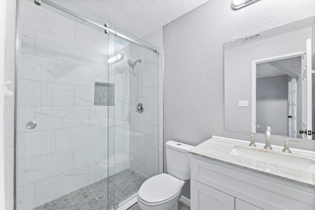 100 West Way Drive Allen, TX 75002 - Photo 18 of 31 Primary Bathroom featuring a textured wall, a walk in shower, vanity, and a textured ceiling