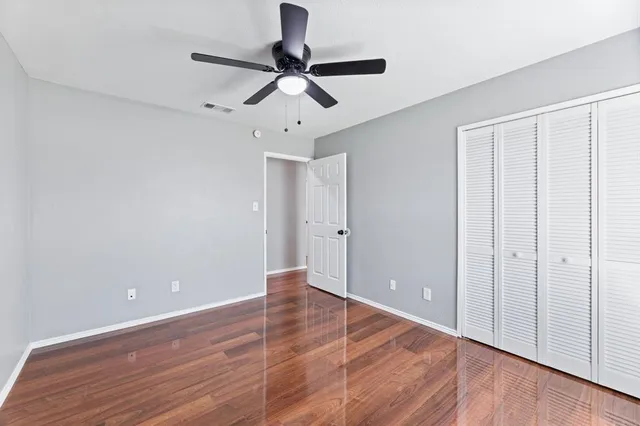 a view of a room with wooden floor and a ceiling fan
